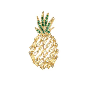 Broche creativo de piña dorada con cristallen verdes y gemas de corte tipo baguette