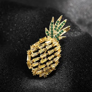 Dettaglio macro di una spilla a forma di ananas dorata con cristalli gialli