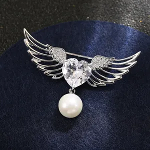 Détail de la broche ailes d'ange en argent avec zircon en cœur et pendentif perle