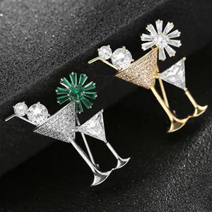 Dettaglio di spille a forma di cocktail con basi in argento e oro e pietre lucide