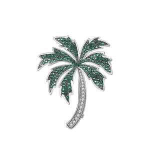 Sparkling palm tree brooch with green and clear crystals in silver metal setting