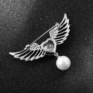 Élégante broche ailes d'ange avec cristal cœur et perle sur fond noir texturé
