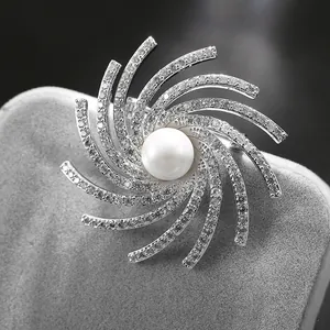 Elegant rotating snowflake brooch with central pearl and sparkling cubic zirconia stones