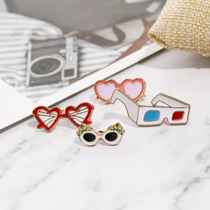 Ensemble de quatre broches lunettes de soleil en émail sur une surface marbre