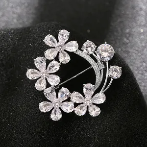 Floral crystal wreath brooch with pear-cut stones on a black textured background