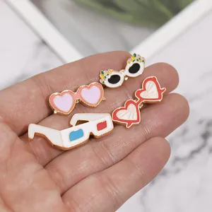 Lot de quatre broches émaillées en forme de lunettes de soleil avec fleurs et cœurs