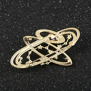 Goldene Galaxie-Brosche mit Planetenringen und Sternen auf dunklem Hintergrund