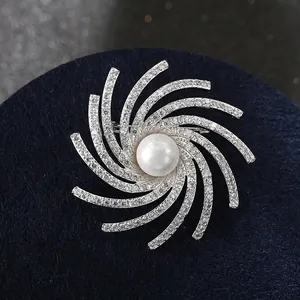 Sparkling silver rotating snowflake brooch with central pearl and zircon accents