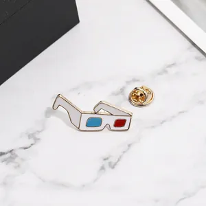 Détail de la broche émaillée lunettes 3D avec verres bleus et rouges sur marbre