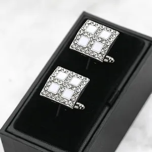 Detail of silver square cufflinks with white enamel inlay and crystal border in a gift box
