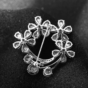 Detail view of the silver floral brooch back showing the pin closure and zircon stones