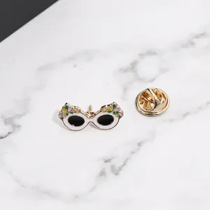 Détail d'un pin's en émail lunettes de soleil œil de chat avec des motifs floraux