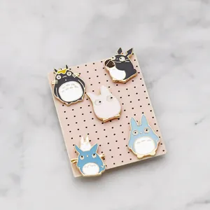 Set di cinque spille Totoro in smalto colorato su carta rosa su piano in marmo