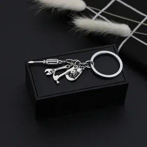 Detail of metal keychain featuring miniature screwdriver, wrench, hammer and cowboy hat charm