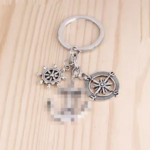 Porte-clés nautique détaillé avec pendentifs boussole et gouvernail en argent mat