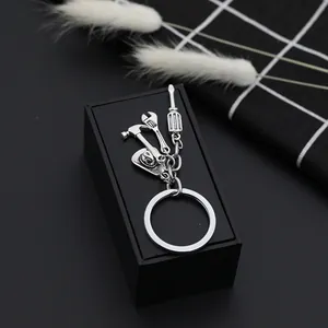 Detail of silver tool keychain featuring mini hammer wrench screwdriver and cowboy hat