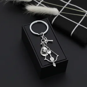 Retro silver cowboy hat and revolver gun alloy keychain pendants on a display box