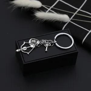 Western style silver cowboy hat and revolver gun pendant keychain on a decorative background