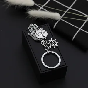 Macro detail of Hamsa Hand and rudder keychain with 'no matter where' engraving