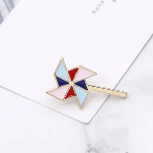 Vue détaillée d'une broche moulin à vent colorée avec monture dorée et pétales émaillés