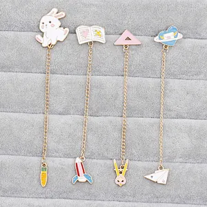 Detailed view of four colorful enamel cartoon brooches with golden chains and cute charms