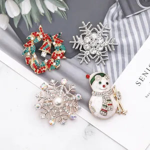 Détail de quatre broches de Noël avec couronne de strass, flocon de neige et bonhomme