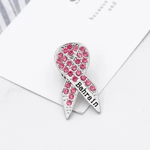 Makroaufnahme der silbernen Bandschleife mit rosa Strass und Bahrain-Schriftzug auf Karte