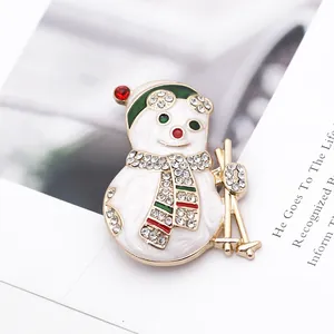 Détail d'une broche bonhomme de neige avec cristaux brillants et émail coloré de Noël