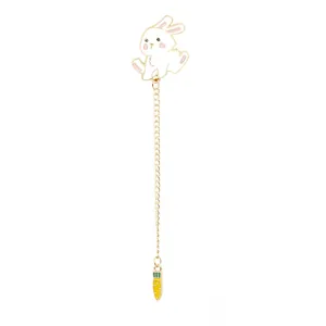 Detail showing gold chain with cartoon white rabbit and orange carrot enamel charms