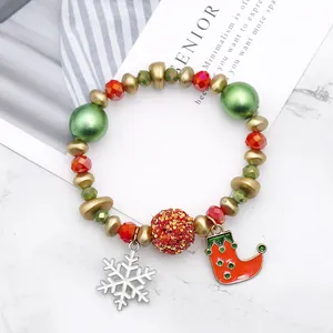 Handgemaakte kerstarmband met kralen, groene accenten en een feestelijke sokhanger