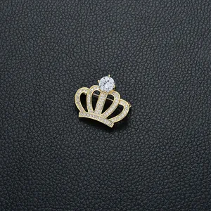 Broche couronne dorée luxueuse avec zircons étincelants sur fond en cuir noir élégant