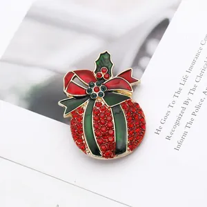 Detail of Christmas holly brooch with red rhinestones and green enamel on a stylized base
