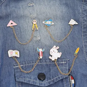 Cartoon enamel pin set with gold chains featuring rabbits and books on denim jacket