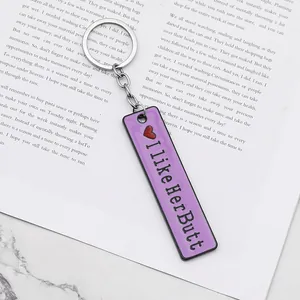Portachiavi rettangolare viola con scritte e cuore rosso su fondo di marmo