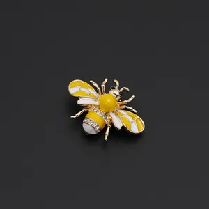 Macro view of gold honey bee brooch with yellow enamel wings and sparkling rhinestones