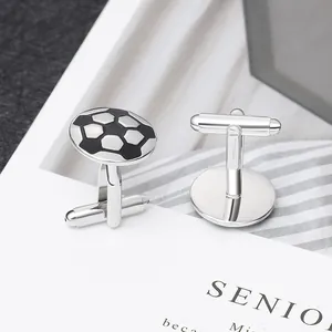 Macro view of polished silver soccer cufflinks with black enamel inlay and swivel bar