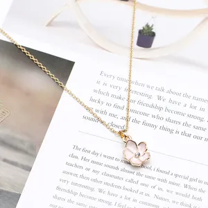 Primo piano dettagliato di una collana con ciondolo a fiore rosa su sfondo letterario