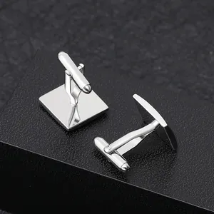 Detail of square silver polished cufflinks with bullet back closure on black texture