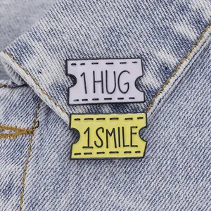 Retro movie ticket enamel pins set featuring 1 HUG and 1 SMILE on denim jacket