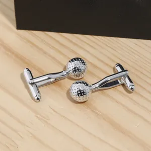 Dettaglio dei gemelli da polso a forma di pallina da golf in argento lucido con texture