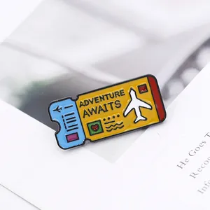 Macro detail of Adventure Awaits plane ticket enamel pin with vibrant metal craftsmanship