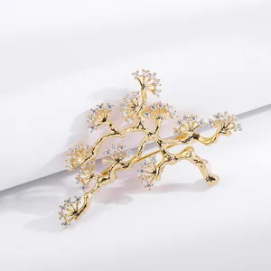 Macro shot of gold-plated pine branch brooch with pavé sparkling white cubic zirconia