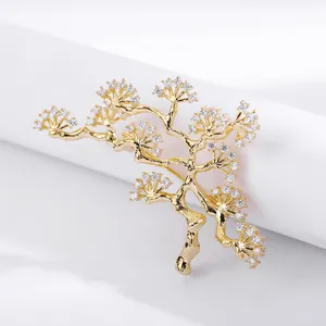 Macro detail of a gold-plated pine tree brooch with sparkling white rhinestones