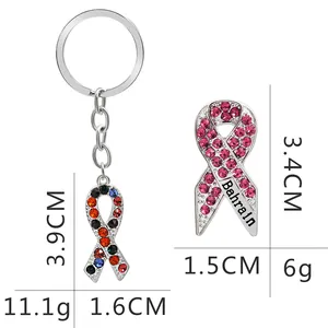 Pink ribbon keychain and Bahrain brooch set with crystals on a white background