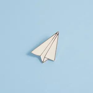 Détail d'une broche avion en papier minimaliste en émail blanc avec bordure argentée