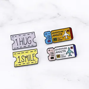 Detail of colorful enamel airplane ticket pins with Adventure Awaits text on marble