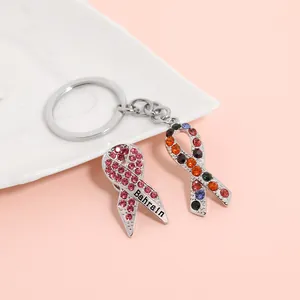 Pink and multicolor rhinestone ribbon pendant keychain with Bahrain text on marble base