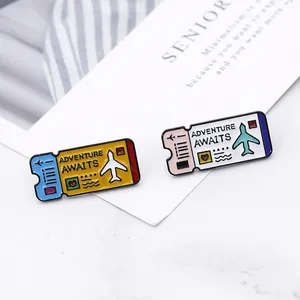 Detail view of colorful enamel airplane ticket pins with Adventure Awaits lettering