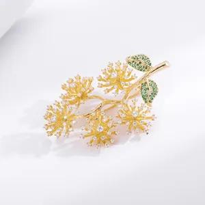 Detailed macro view of gold branch brooch with sparkling white and green zircon stones