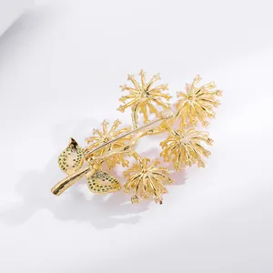 Detail of gold pine branch brooch with green crystals and refined metallic texture